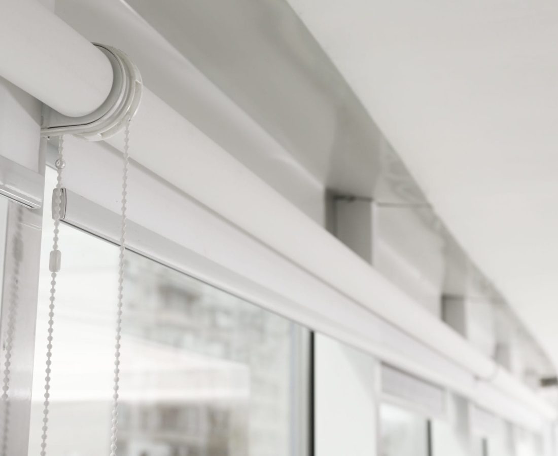 Modern window with white roller blinds indoors